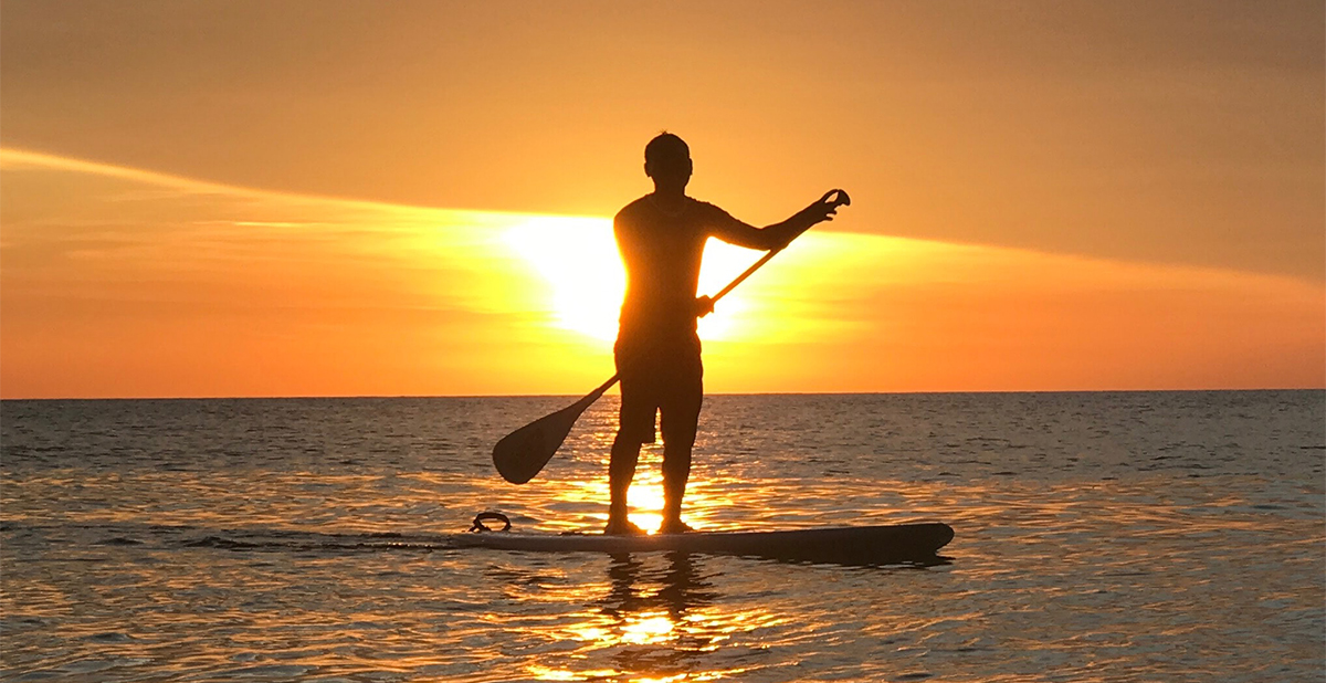 Man paddleboarding at sunset at the North Carolina Crystal Coast