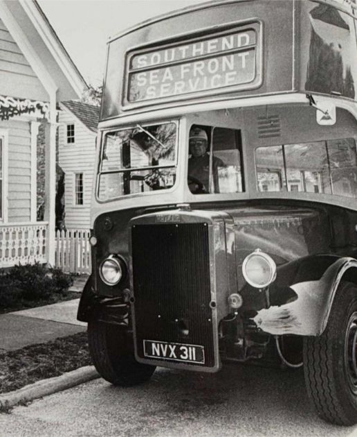 A vintage double-decker bus parked on a street with a sign reading “Southend Sea Front Service.”